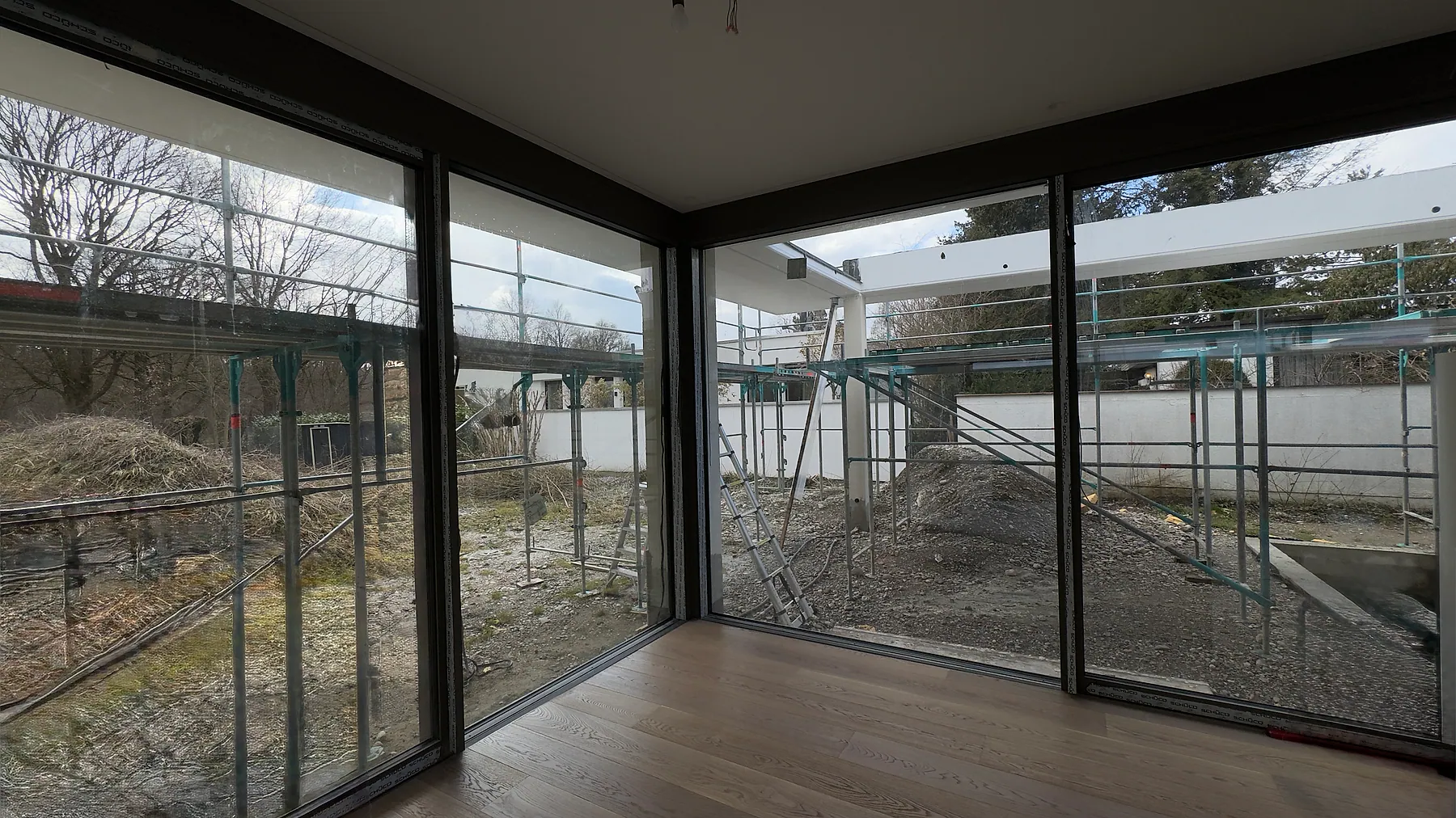 Wohnraum mit großformatiger Aluminium-Eckverglasung während – Aluminium-Projektreferenz auf der Seite Projekte & Referenzen | Aluminiumfenster